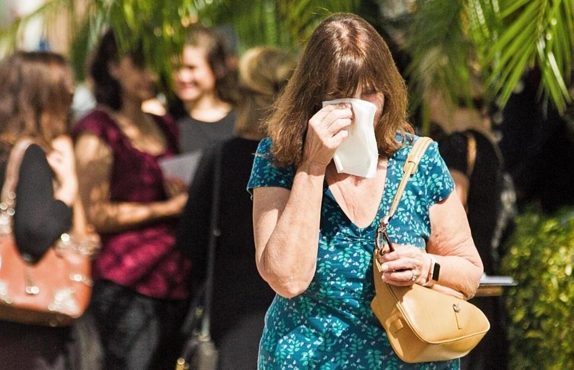 A mourner wipes a tear as she exits the funeral home holding services for Martin Duque on Sunday, Feb. 25, 2018.
