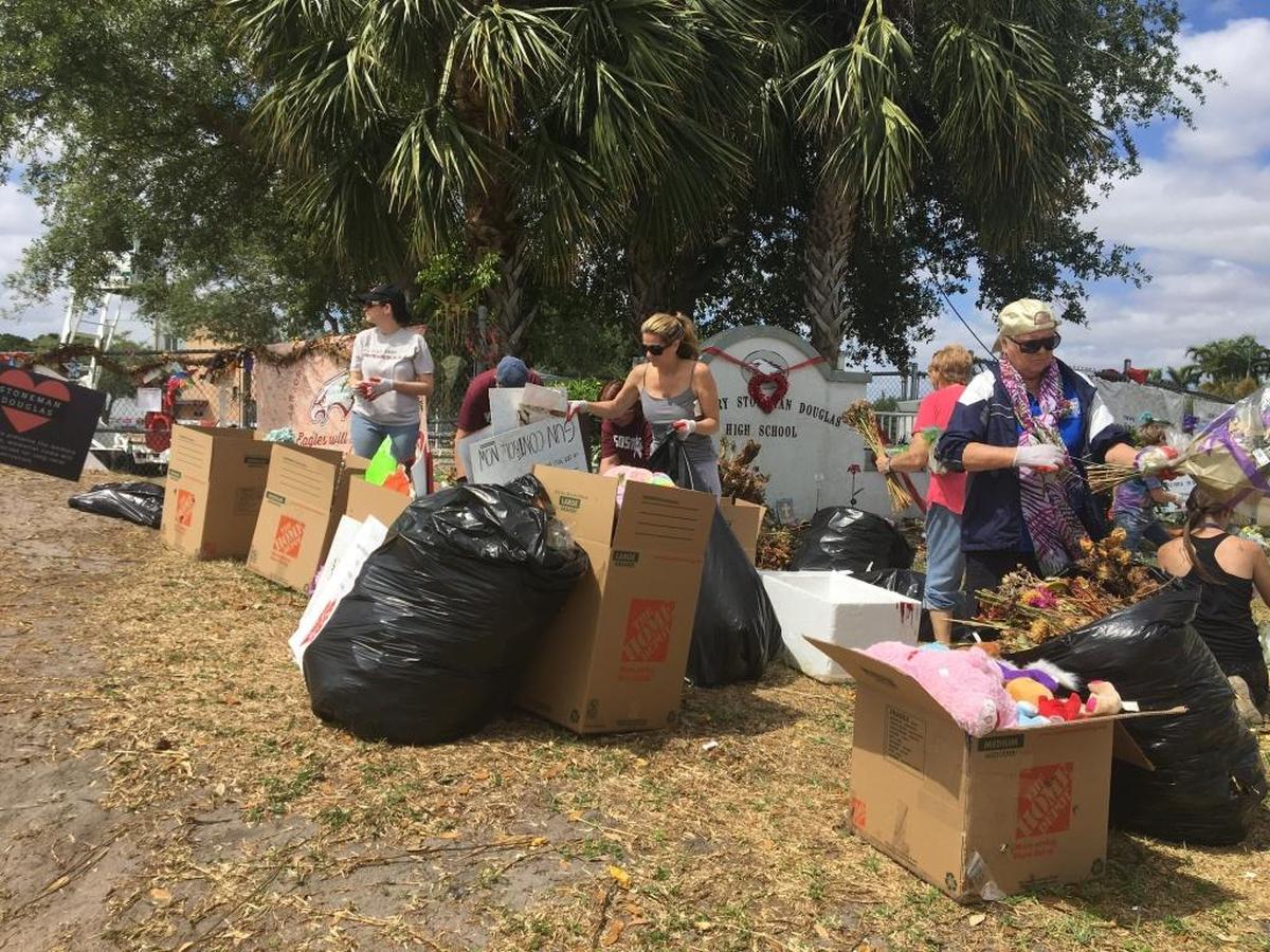 Volunteers work to dismantle the memorial outside Marjory Stoneman Douglas High School on Wednesday.