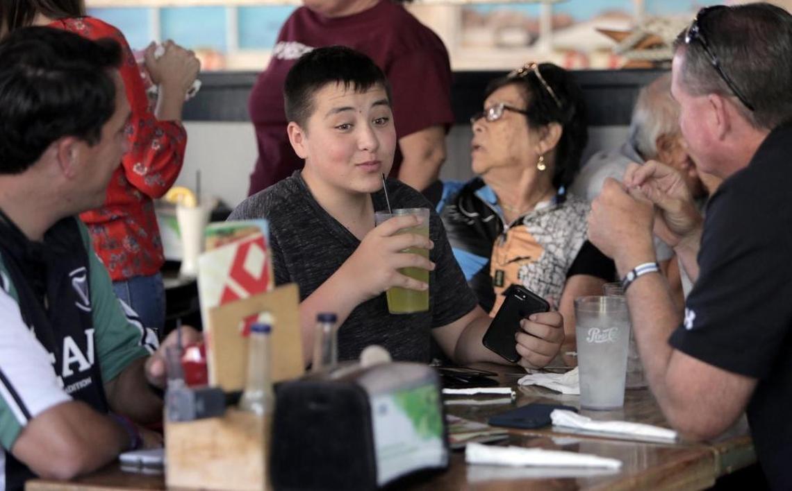 Surrounded by family and friends while sipping a cold drink, Kyle Laman attends a fundraiser for his recovery held at Hurricane Wings & Grill on April 28. Ten percent of total sales on that day went to his fund. Seated to the left is Coral Springs Commissioner Larry Vignola and on the right is Sgt. Jeff Heinrich, who treated Kyle’s wound on the day of the shooting.