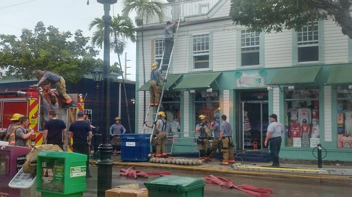 Key West firefighters after knocking down an early-morning fire Tuesday on Duval Street that began on a lane behind these buildings.