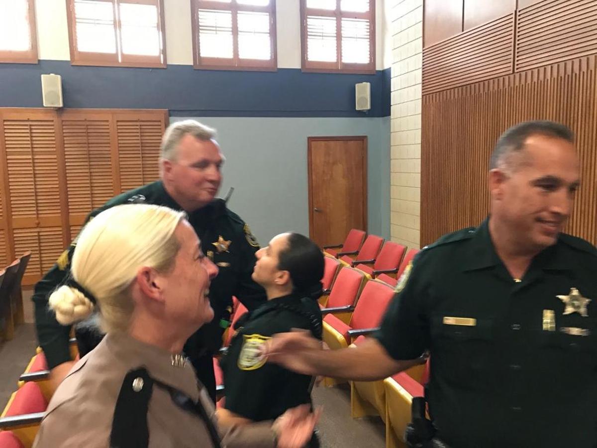 Law enforcement officers, including Florida Highway Patrol Cpl. Christine Gracey (tan uniform) and Monroe County Sheriff’s Office Sgt. Sydney Whitehouse (back), celebrate in the Plantation Key courthouse on Jan. 21, 2018, after a jury found Robert Schminky guilty of first-degree attempted murder related to a Jan. 21, 2015, shootout with Gracey and Whitehouse.