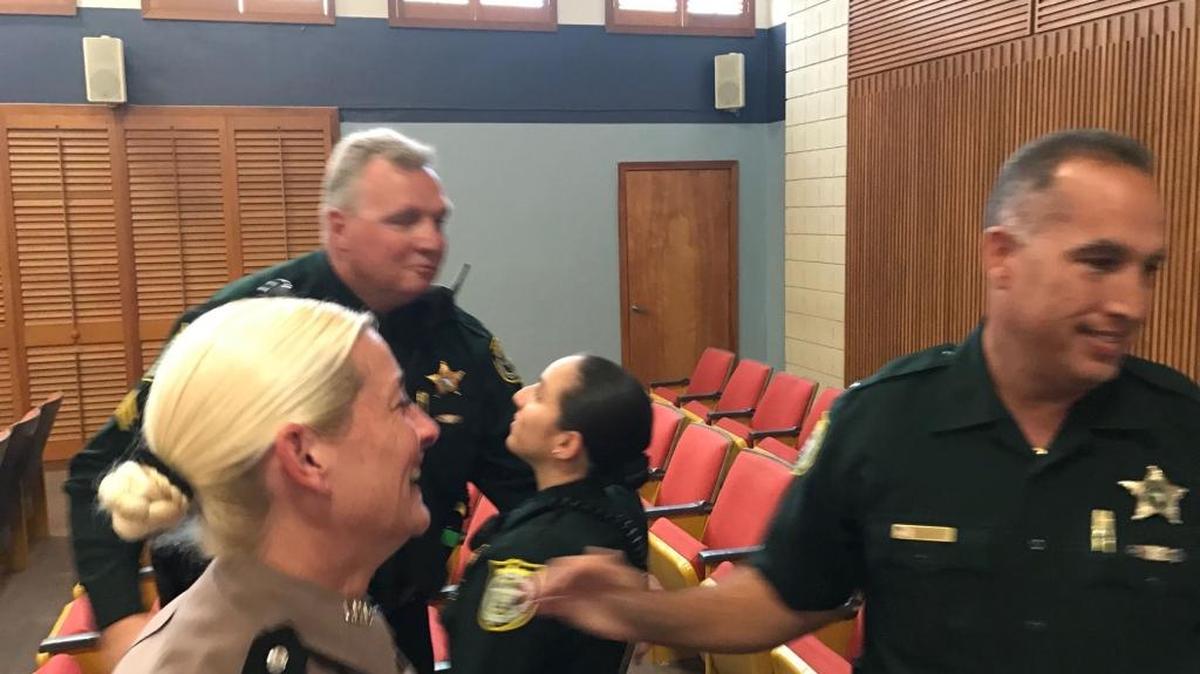 Law enforcement officers, including Florida Highway Patrol Cpl. Christine Gracey (tan uniform) and Monroe County Sheriff’s Office Sgt. Sydney Whitehouse (back), celebrate in the Plantation Key courthouse Tuesday, Jan. 21, 2018, after a jury found Robert Schminky guilty of first-degree attempted murder related to a Jan. 21, 2015, shootout with Gracey and Whitehouse.