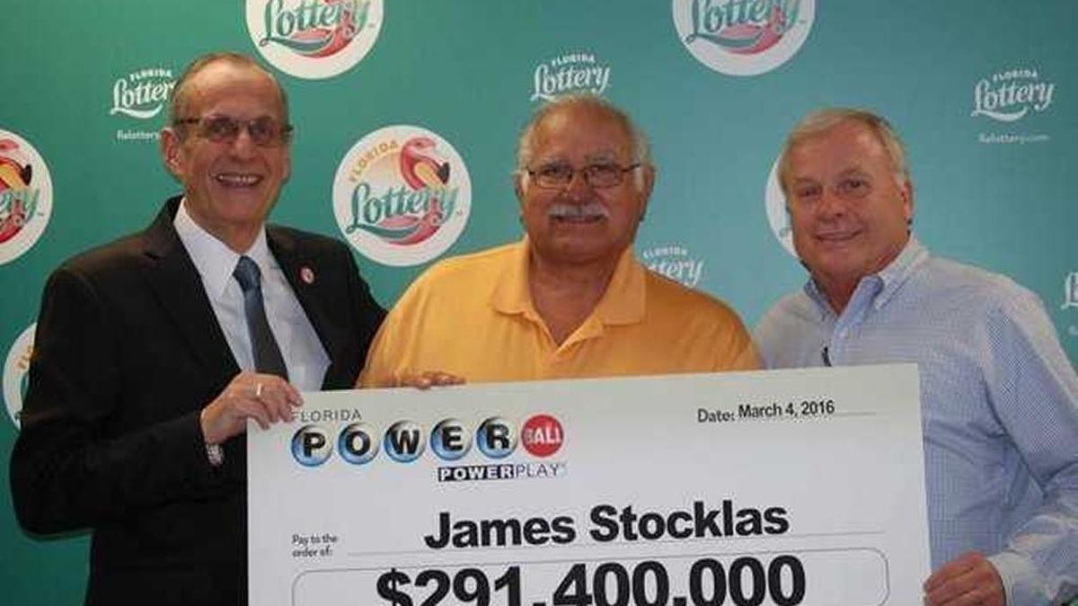 Florida Lottery Secretary Tom Delacenserie poses Friday at lottery headquarters in Tallahassee with Powerball jackpot winner James Stocklas and his friend, Barry Bartakovits.
