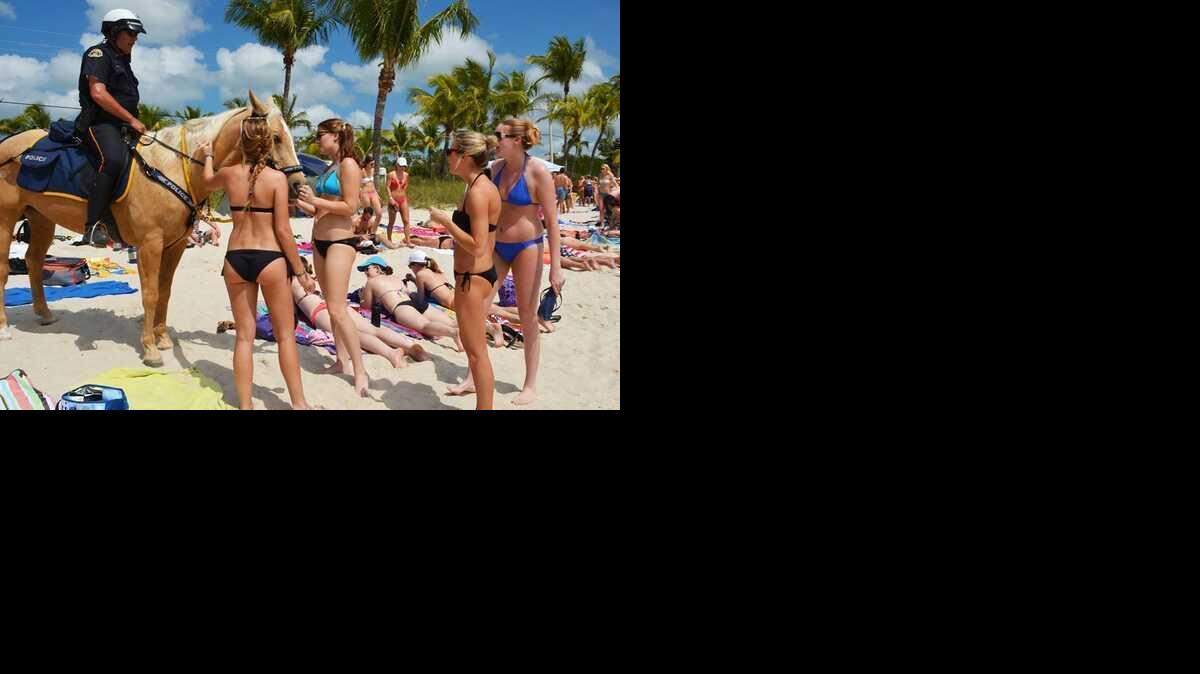 
Spring-breakers gather to greet a police horse on SMathers Beach in Key West.
