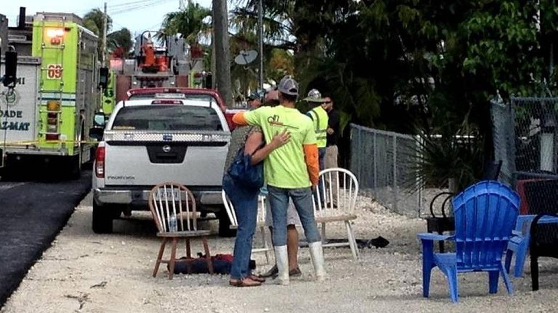 D.N. Higgins workers console each other following the deaths of three of their colleagues inside a 15-foot-deep drainage hole on Jan. 16 in the Key Largo Lake Surprise Estates subdivision. David Goodhue The Reporter