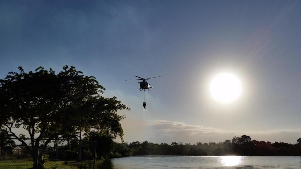 Miami-Dade Fire Rescue drops water on a brush fire near Card Sound Road Monday.