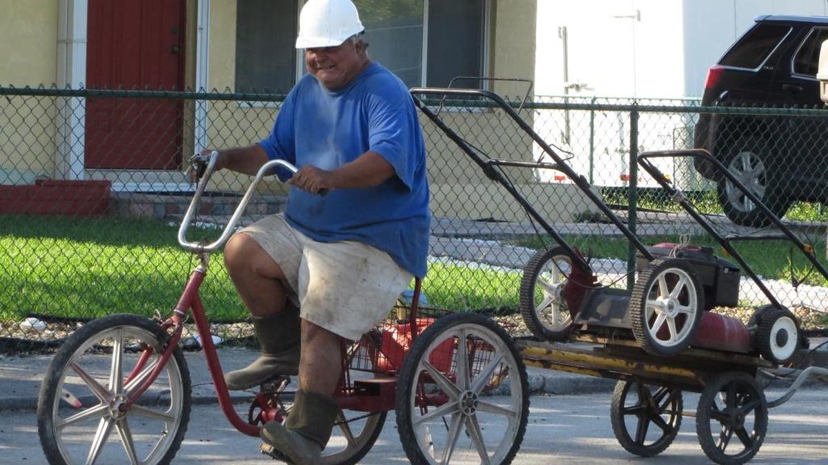 Mario Cruz drives a batch of busted lawn mowers he said he would repair to sell down Cross Street on Stock Island.