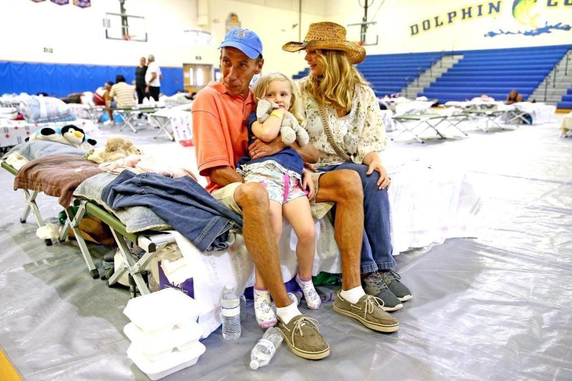 Brad and Syria Ingram with their daughter Luna, 3, sit in a Red Cross shelter at Marathon High School in the Florida Keys, Wednesday, Sept. 20, 2017. The Ingram's live-a-board boat sunk after the storm and before they could get past the road blocks to return to the Keys.