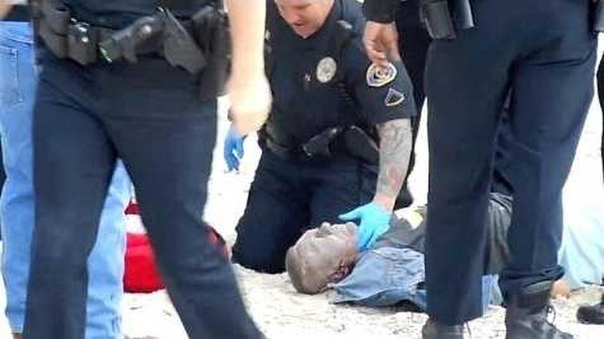 This is an image taken from a YouTube video of the police takedown at South Beach. Charles Eimers is in the sand surrounded by police. He died later at a hospital.