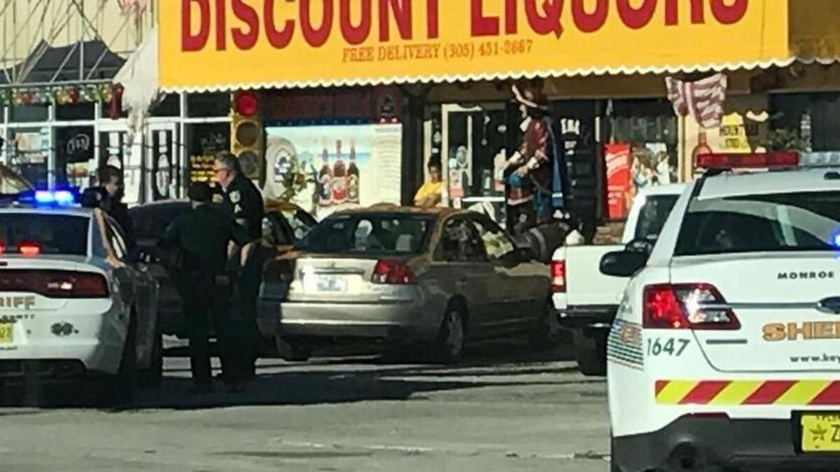 Monroe County Sheriff’s Office deputies stand by a patrol car that is behind a black Dodge Charger that was pulled over in the parking lot of Denny’s Liquors following a road rage incident Thursday morning, Dec. 14.