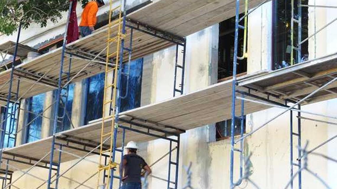 A construction crew works on the new city hall where the windows are being installed. The $18.8 million project is due for completion this summer.