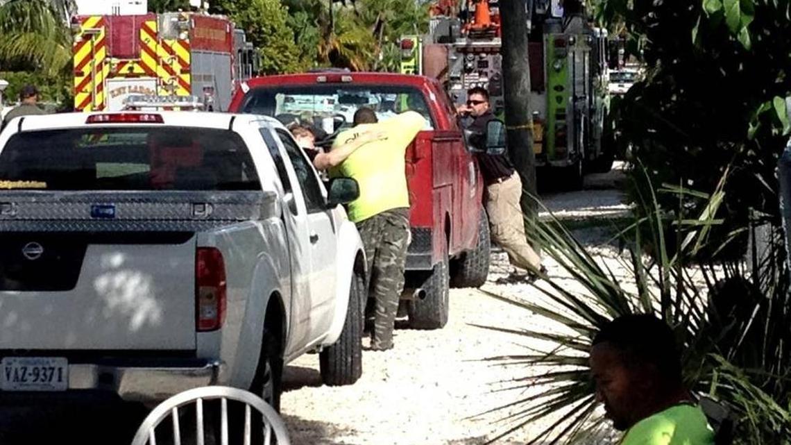 A woman comforts a man at the site of Monday’s tragedy in Key Largo during which three utility workers died in a wastewater trench.