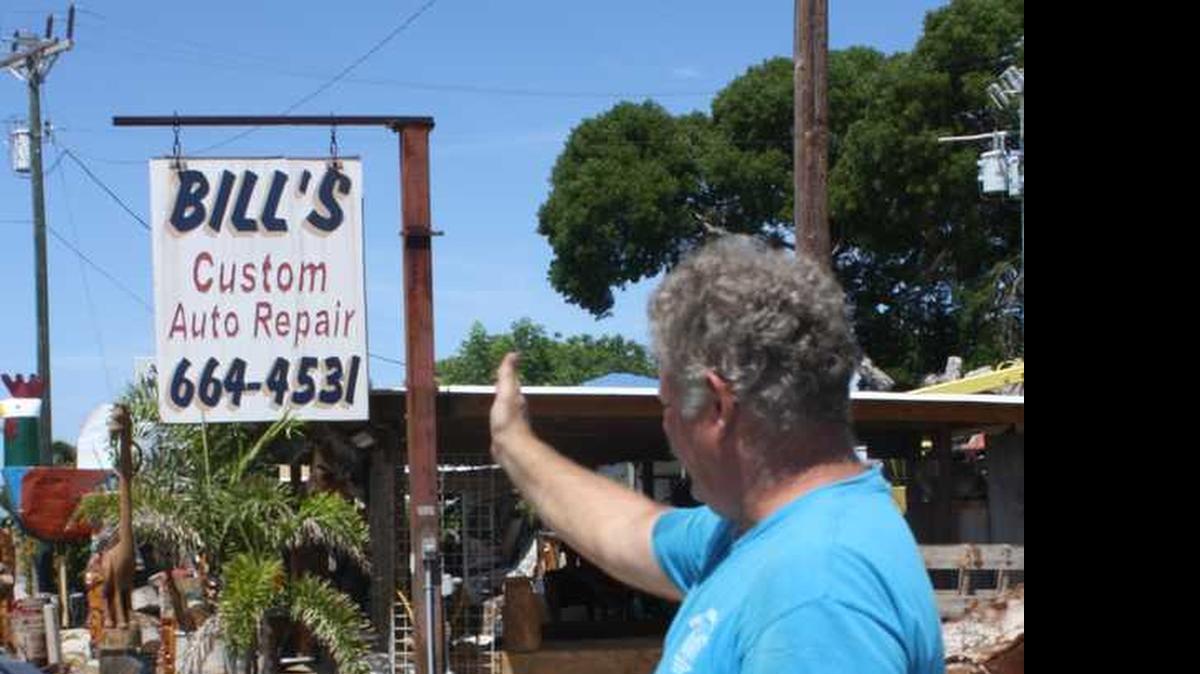
Bill Ismer, owner of Bill's Custom Auto Repair in Islamorada, points to his business' sign, which has been there since the 1950s. The Florida Department of Transportation says the sign is on state-owned land. 
