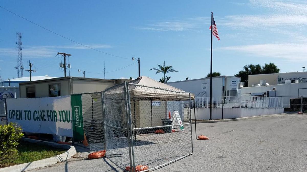 Since Sept. 26, some services at Fishermen’s Community Hospital have been offered in tents (left) and mobile buildings. The actual hospital, in the rear, was severely damaged in the hurricane.