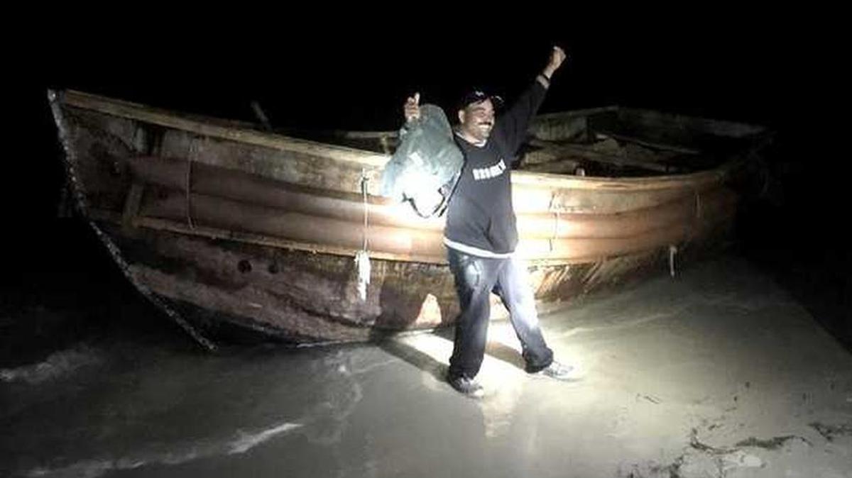 One of 23 Cuban migrants exults after landing on a Keys Beach.