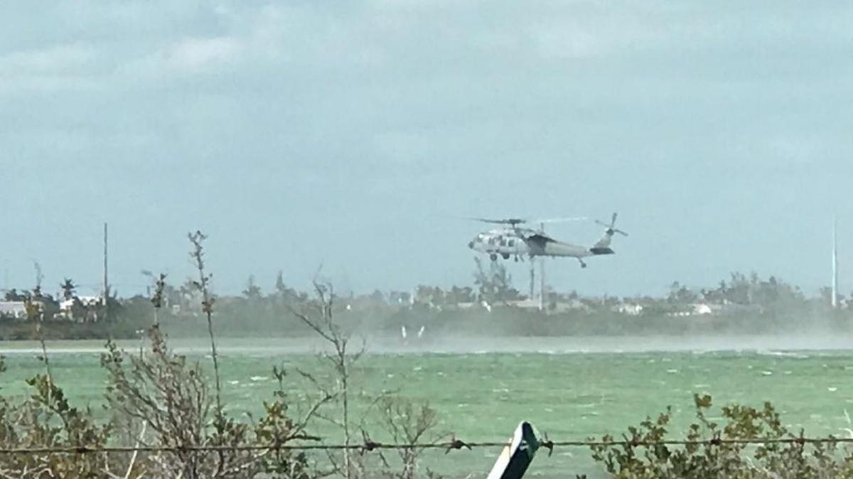 A United States Navy helicopter hovers over the wreckage of an F-18 fighter jet that crashed into the water off Naval Air Station Key West Wednesday afternoon.