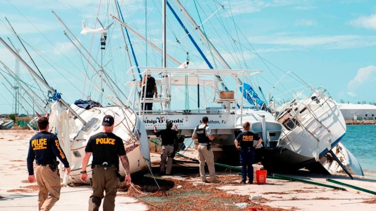 Agents from Coast Guard Investigative Service inspect aground sailboats and debris at the Trumbo Point Annex for Naval Air Station Key West on Sept. 15. Boats in the Navy’s jurisdiction face a deadline for removal.