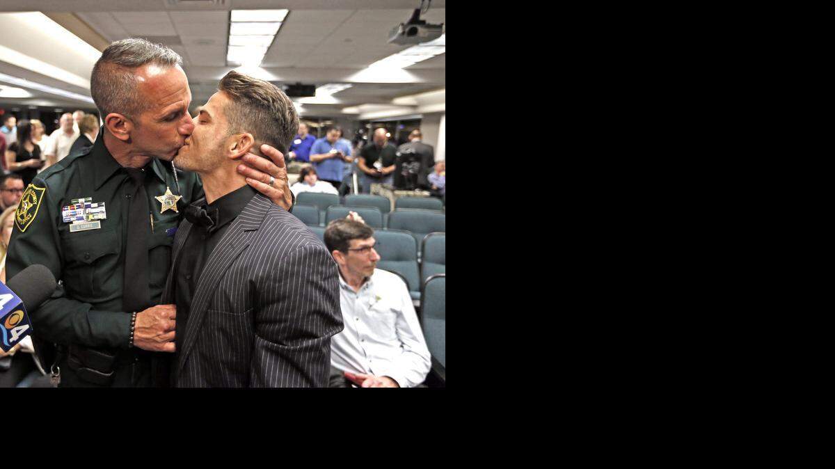 
Broward Sheriff’s Office officer David Currie and Aaron Woodard kiss after a mass wedding at the Broward County Courthouse in Fort Lauderdale.

