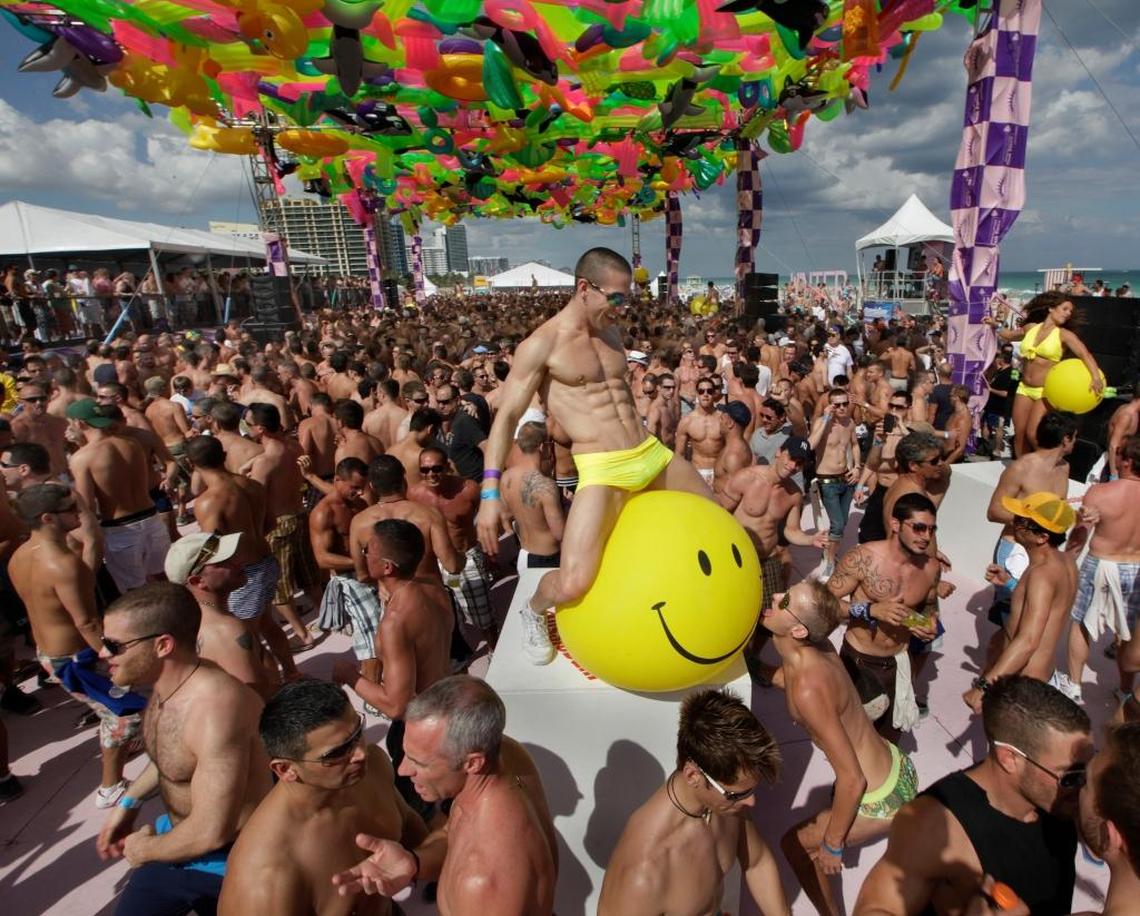Amir Hamza, a volunteer from Las Vegas, dances with a large yellow smiley face balloon on a raised platform beneath a canopy of inflatable pool floats at the Winter Party Festival on Miami Beach, sponsored by the National LGBTQ Task Force, on March 1, 2009.