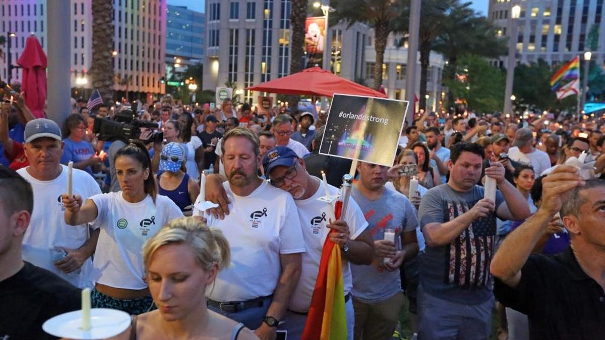 Dr. Ron Campbell and his husband, Dwayne Wesley-Campbell, lean on each other as they hold candles and listen to the church bells toll for the number of those killed in the Pulse Nightclub shooting. Thousands of people attended a vigil for the victims of the Pulse nightclub shooting. The vigil was on the lawn of the Dr. Phillips Center for the Performing Arts, Monday evening, June 13, 2016.