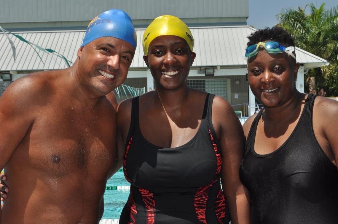 Miami swimmer Dino Mosquera with World OutGames competitors Clare Byarugaba and Diane Bakuraira of Uganda on Sunday at Ransom Everglades School in Coconut Grove.