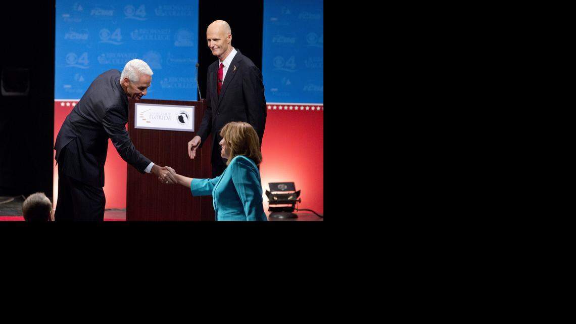 
Democratic challenger, former Republican Gov. Charlie Crist, left, and Florida Republican Gov. Rick Scott, right, shake hands with moderator Rosemary Goudreau after a debate, Wednesday, Oct. 15, 2014 in Davie, Fla.
