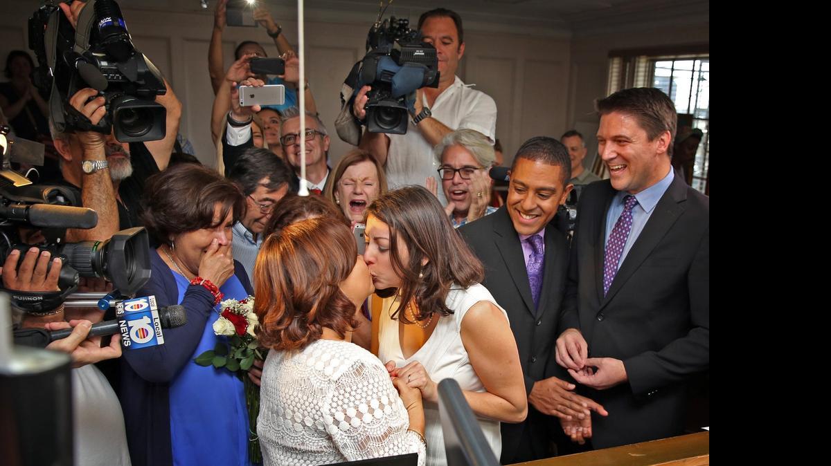
On Jan. 5 in Miami, Karla Arguello ( back to camera) and Cathy Pareto (facing camera) exchange vows in front of Judge Sarah Zabel, with Jeff and Todd Delmay looking on. Earlier that day, Zabel was the first judge authorize same-sex marriages in Florida. 
