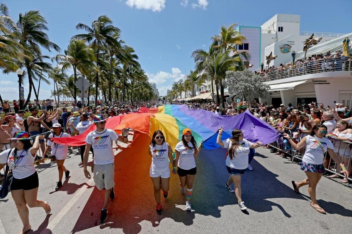 Folks carry a large rainbow flag along the parade route on Ocean Drive during the 2016 Miami Beach Gay Pride parade.