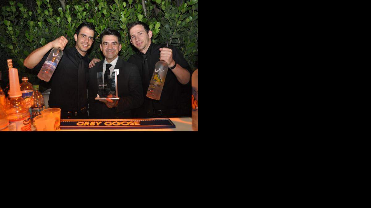 
Honoree Joe Plana, special events manager of Bacardi USA in Coral Gables, flanked by two Bacardi bartenders in Miami Beach Friday night at the 2015 annual Winter Party VIP reception.
