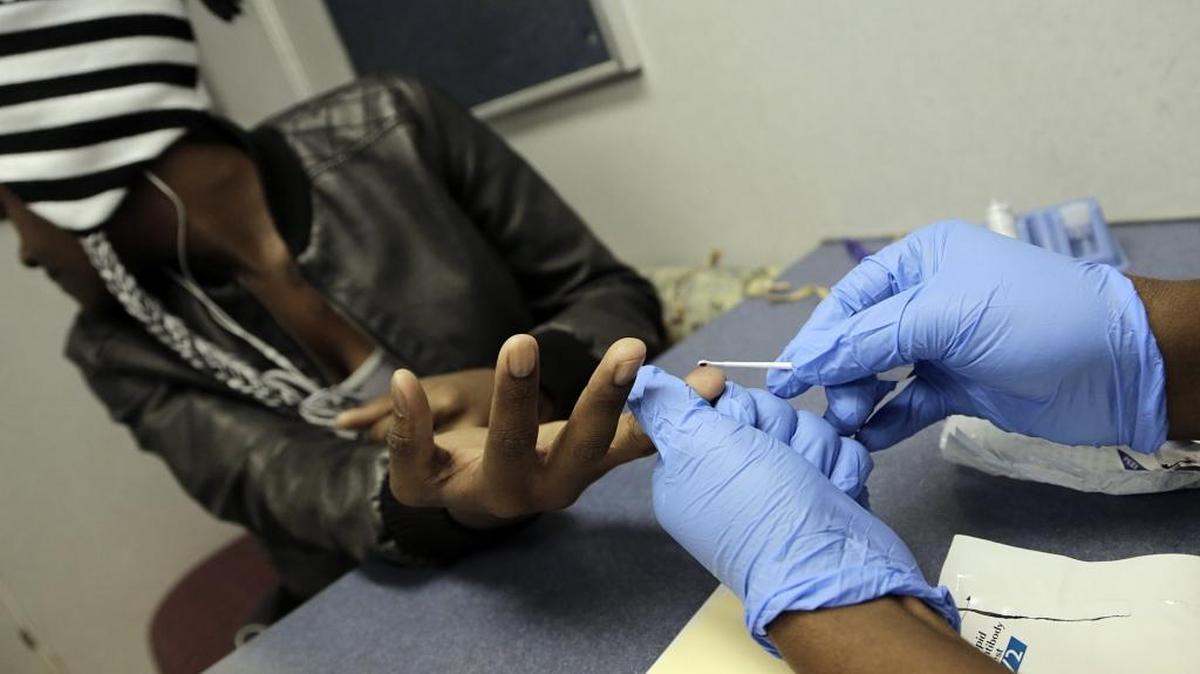 A client takes an HIV blood test inside a mobile clinic in Miami.