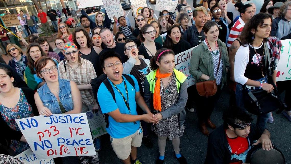 Protesters chant at an intersection in Chapel Hill, N.C., Tuesday, March 29, 2016 to protest the recent passage of N.C. HB2, which prevents local governments from protecting people on the basis of sexual orientation and gender identity when they use public accommodations such as hotels and restaurants. People also would have to use multi-stall bathrooms that match their birth certificates at state agencies and public schools and universities.