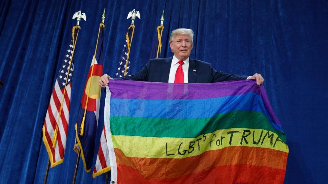 Republican presidential candidate Donald Trump holds an LGBTQ-pride rainbow flag as he arrives to a campaign rally at the University of Northern Colorado, Sunday, Oct. 30, 2016, in Greeley, Colorado