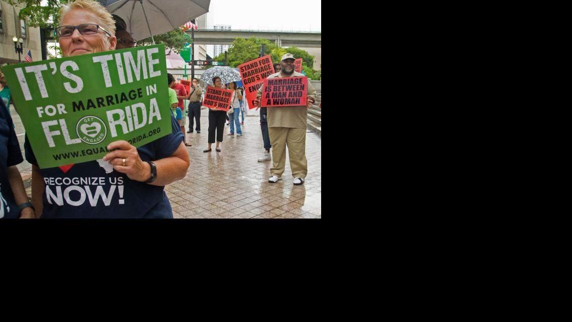 
Donna Deptuch, left, attends a July 2014 rally outside the Miami-Dade Courthouse in Miami. LGBT activists stood alongside members of the Christian Coalition outside the courthouse while six same-sex couples inside asked a Miami-Dade judge to issue them marriage licenses.
