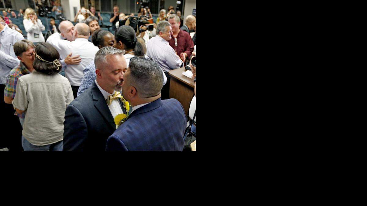 
Rich Matthews and Carlos Noda kiss during a mass wedding at the Broward County Courthouse in Fort Lauderdale early Jan. 6, 2014.
