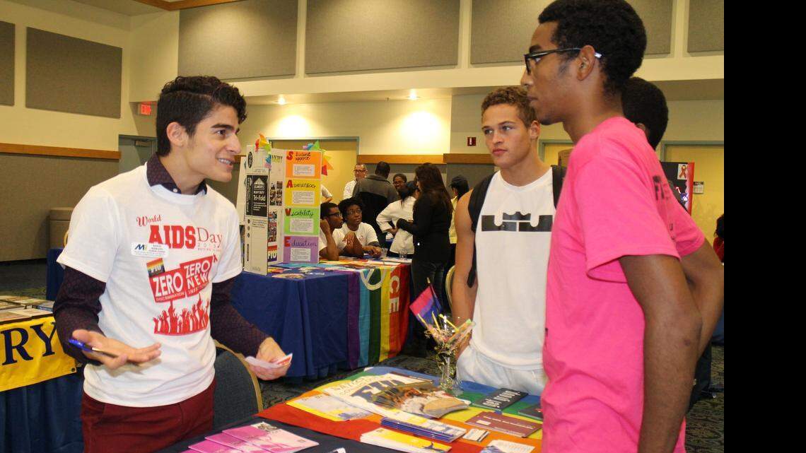 
Edwin Serrano, left, a graduate assistant for LGBTQA Initiatives at Florida International University, speaks with sophomores Willy Silva, center, and Joel Batista, at FIU's World AIDS Day 2013 resource fair.
