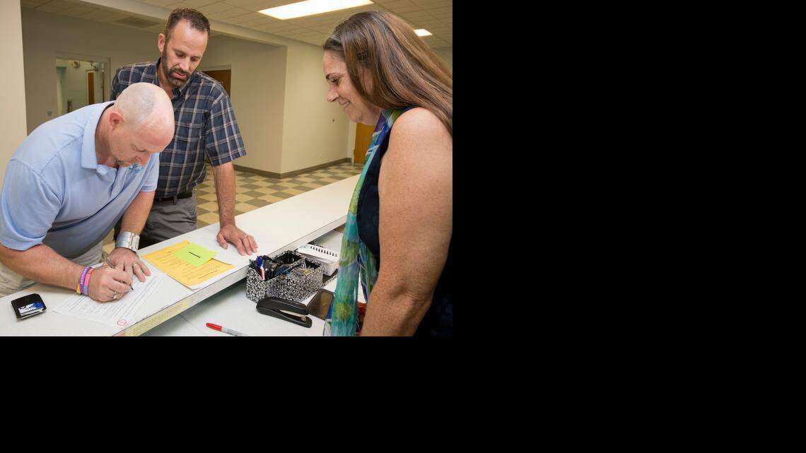 
William Lee Jones, left, and Aaron Huntsman, center, complete a marriage license application at the Monroe County Courthouse Friday, Jan. 2, in Key West, Fla. At right is Monroe County Clerk Amy Heavilin.
