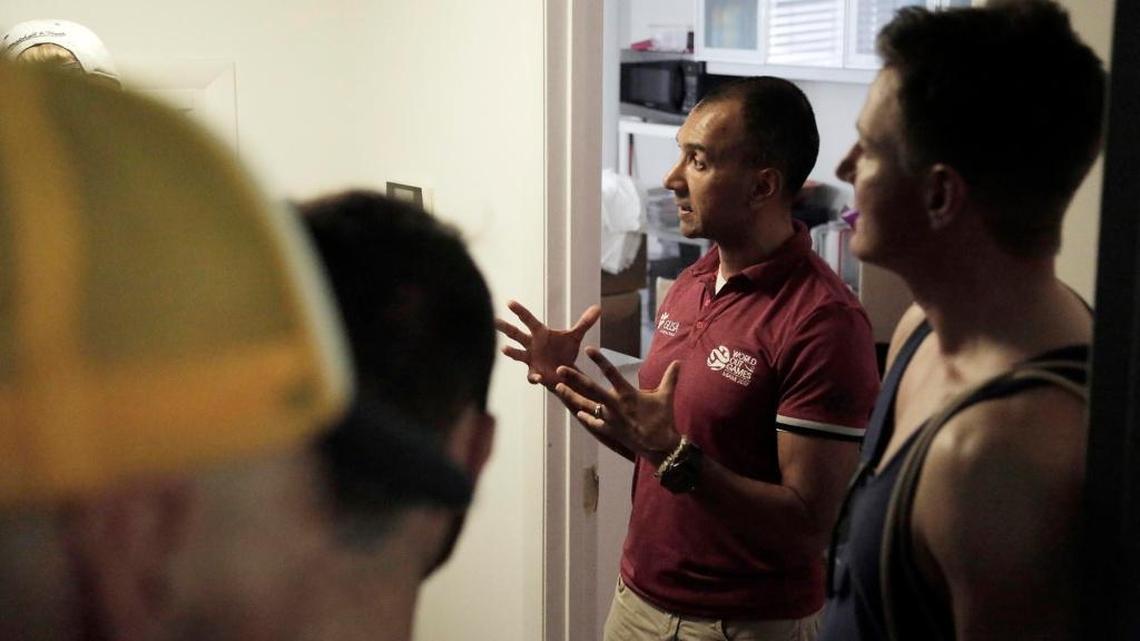 OutGames CEO Ivan Cano, second from right, speaks to athletes who are looking for an explanation at the offices of the World OutGames in Miami Beach on Friday.