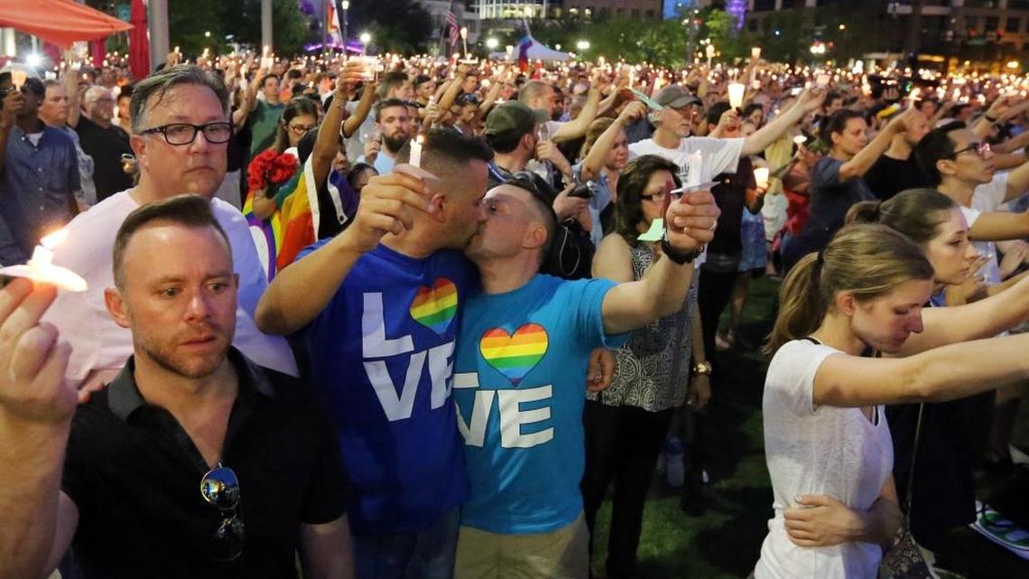 Bobby Bongiorno and Eric Ferrari share a kiss as they hold candles along with thousands of others who attended a vigil for the victims of the Pulse nightclub shooting. The vigil was on the lawn of the Dr. Phillips Center for the Performing Arts, Monday evening, June 13, 2016.
