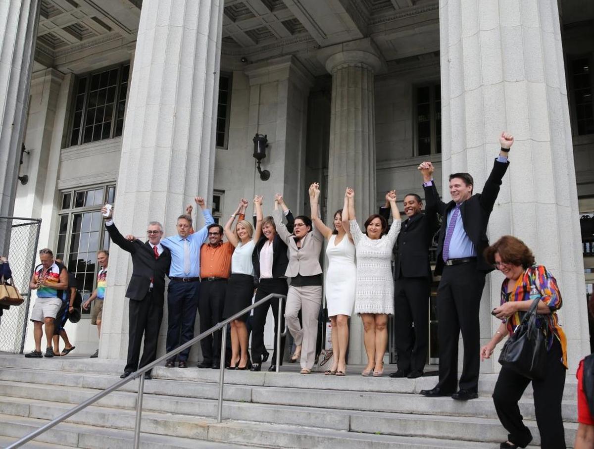 Attorney Elizabeth Schwartz, center, joins hands with plaintiffs in the gay marriage ruling on the Miami-Dade County courthouse steps after the ban was successfully lifted on Jan. 5, 2015, by Circuit Judge Sarah Zabel.