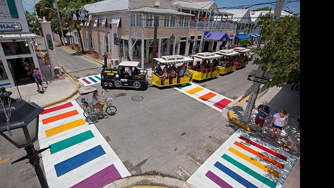 
A Conch Tour Train turns at Duval and Petronia streets Thursday, May 28, 2015, in Key West, Fla., just after city workers installed four rainbow crosswalks. The crosswalks feature bands of all six colors of the rainbow flag, an internationally recognized symbol of gay and lesbian unity. The crosswalks are composed of pre-formed thermoplastic color blocks alternating with white stripes, heat-treated to become a permanent part of the pavement.

