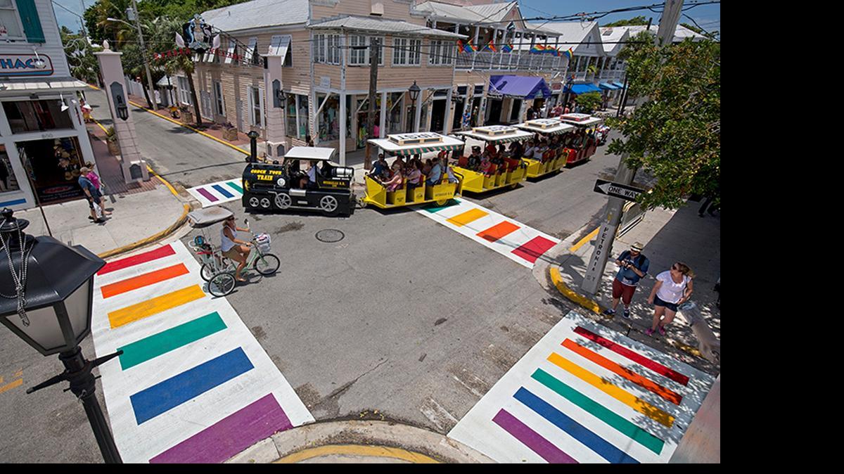 
A Conch Tour Train turns at Duval and Petronia streets Thursday, May 28, 2015, in Key West, Fla., just after city workers installed four rainbow crosswalks. The crosswalks feature bands of all six colors of the rainbow flag, an internationally recognized symbol of gay and lesbian unity. The crosswalks are composed of pre-formed thermoplastic color blocks alternating with white stripes, heat-treated to become a permanent part of the pavement.
