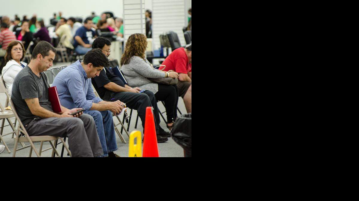 
People wait to speak with an insurance agent from Sunshine Life and Health Advisors as they discuss plans available from the Affordable Care Act at a store setup in the Mall of the Americas.
