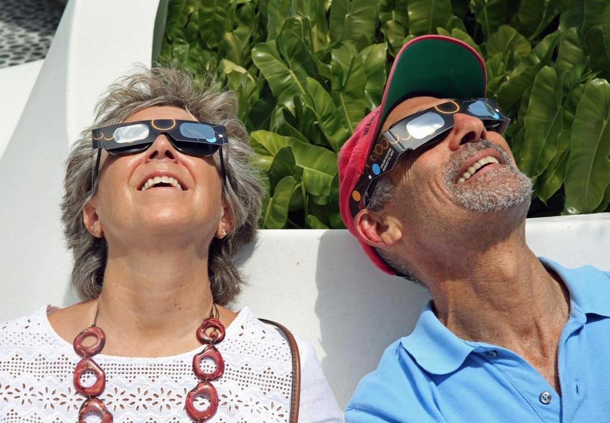 Lynn Capaldo and Jonathan Katzen enjoy the solar eclipse at the Phillip and Patricia Frost Museum of Science in downtown Miami on Monday, Aug. 21, 2017.