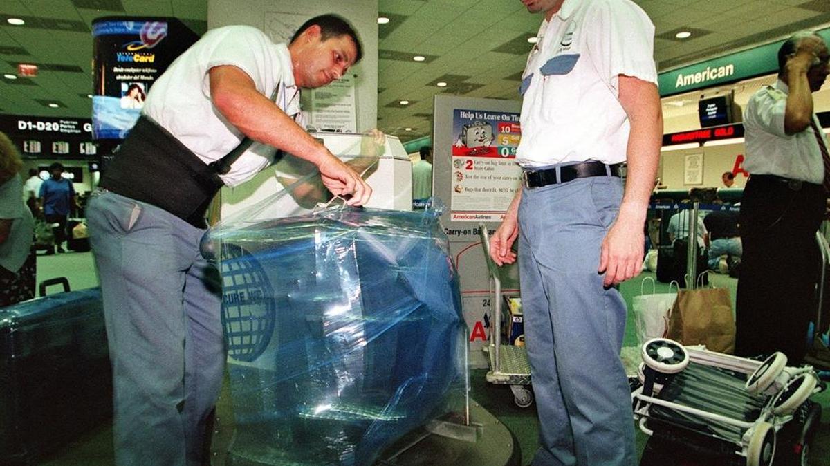 Workers at one of Secure Wrap’s kiosks at Miami International Airport, popular stops for international travelers worried about luggage being pilfered beyond security. The company operates under the Safe Wrap brand.