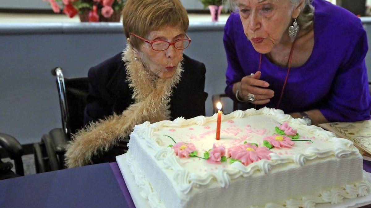
Tilly Harris celebrates her 106th birthday by blowing out a single candle on her birthday cake with the help of her niece, Sallie Latch, during a party at Miami Jewish Health Systems, Thursday, Aug. 13, 2015.
