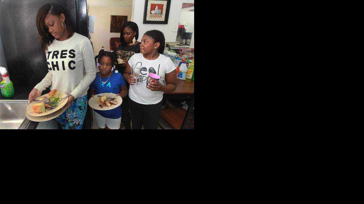 
Alicia Smith, (center in black shirt) cleans up lunch with her daughters Jakira, (right in white shirt) Asia, (center right in blue shirt) and Shanteria, (left) in white shirt) Tuesday, November 11, 2014. The Smiths are one of the working families highlighted by a new United Way study that looks closely at the struggles of the working poor.
