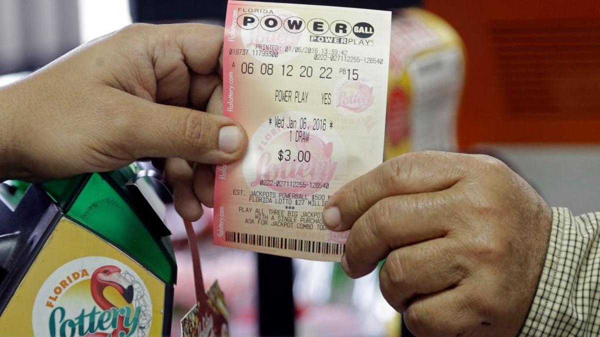 A clerk hands over a Powerball ticket to a customer Wednesday at a grocery store in Hialeah.