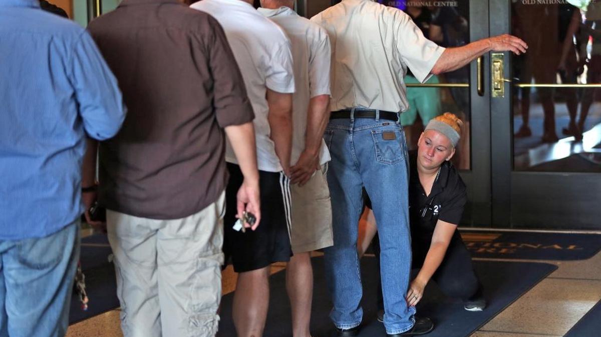 Security checks people entering the Old National Centre in Indianapolis, Ind., before a vigil, Sunday, June 12, 2016, to remember those who died and were injured in the Orlando mass shooting at the Pulse, a gay nightclub just south of downtown Orlando.