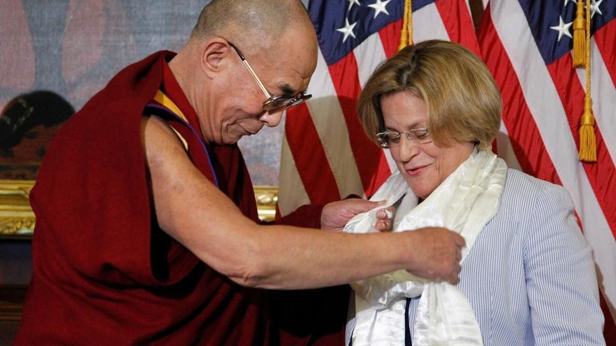 The Dalai Lama adjusts the scarf of Rep. Ileana Ros-Lehtinen, R-Fla. as he was welcomed on Capitol Hill in Washington on July 7, 2011.