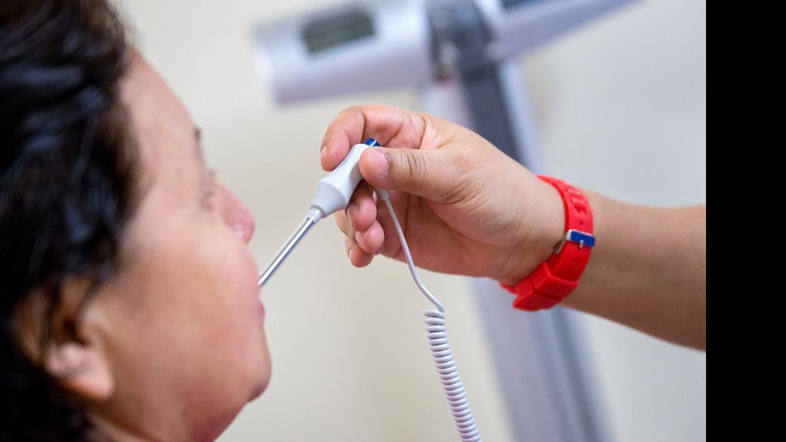 
A medical assistant takes a patient's temperature at a clinic in Silver Spring, Maryland.

